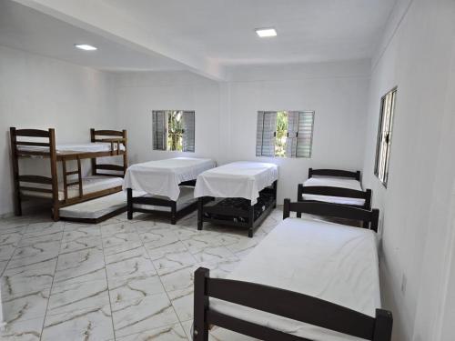 a room with three beds in a room at Chácara da família Santos in Itupeva
