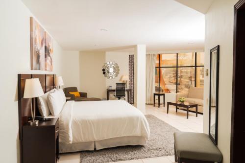 a bedroom with a bed and a living room at Hotel Los Andes in San Pedro Sula