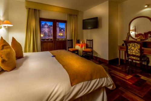 a bedroom with a large bed and a mirror at El Virrey Boutique in Cusco