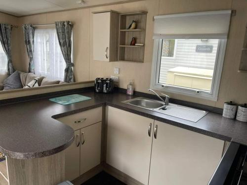 a kitchen with a counter top and a sink at Lovely 6 berth caravan Haven wild duck hoilday park in Belton