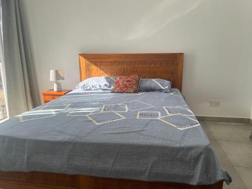 a bedroom with a bed with a blue comforter at Villa Lune D'Eau in Poste Lafayette