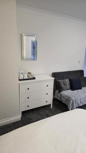 a bedroom with a white dresser and a mirror at Haybow Farm Accommodation in Rolstone