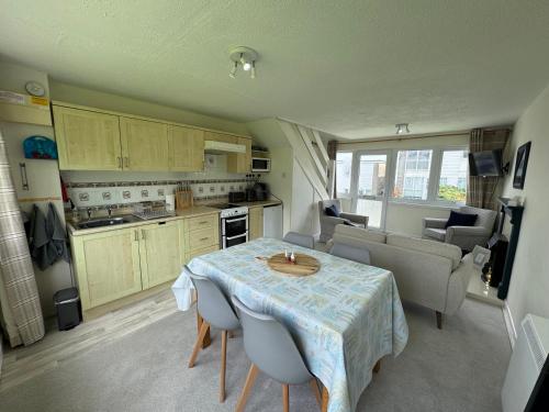 a kitchen and dining room with a table and chairs at 206 Trewent Park in Freshwater East