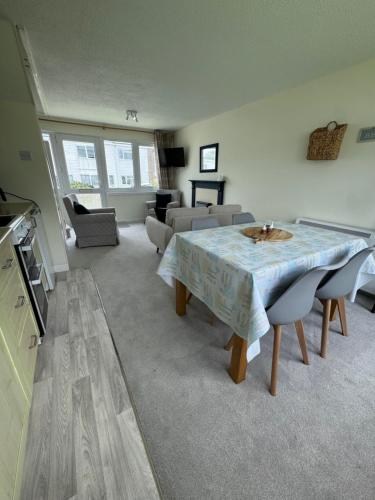 a living room with a table and a couch at 206 Trewent Park in Freshwater East