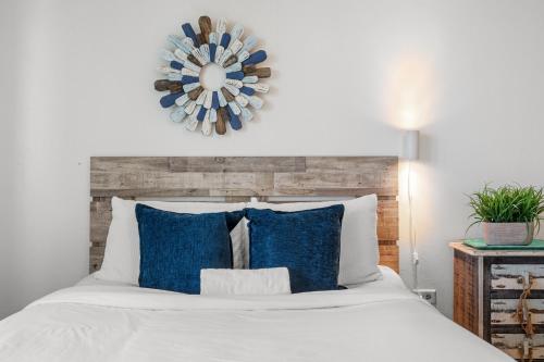a bedroom with a white bed with blue pillows at Condado Lagoon by Otium in San Juan