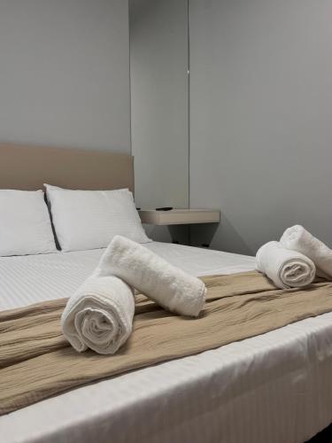 a bedroom with a bed with towels on it at RomanRest in Loutra Edipsou