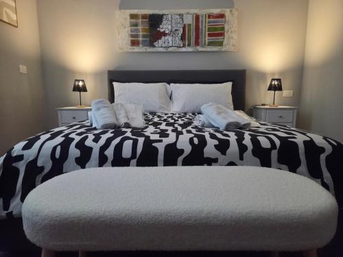 a bedroom with a black and white bed with two lamps at Cà Fiamma 3 in Casale Monferrato