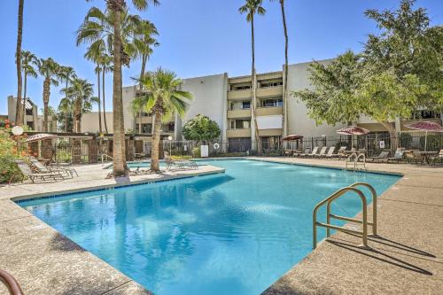 a swimming pool with palm trees in front of a building at Walkable Old Town Scottsdale Condo Pool and Hot Tub in Scottsdale