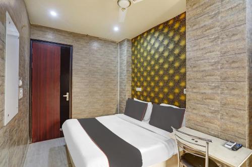 a bedroom with a white bed and a wooden door at Collection O Model Town Metro View in New Delhi