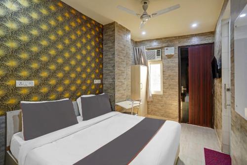 a bedroom with a large bed and a yellow wall at Collection O Model Town Metro View in New Delhi