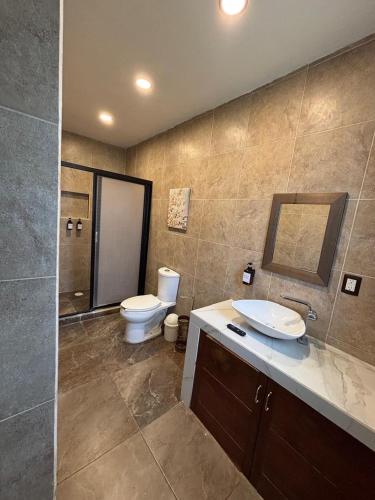 a bathroom with a toilet and a sink and a mirror at Hotel Boutique Casa Zafra in Campeche