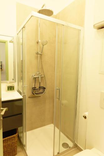 une douche avec une porte vitrée dans une salle de bain dans l'établissement Studio au coeur du Vieux Nice - Vue mer et clocher, à Nice