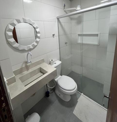 a bathroom with a toilet and a sink and a mirror at Estúdio 101 - 10 minutos da rodoviária e aeroporto in Brasilia