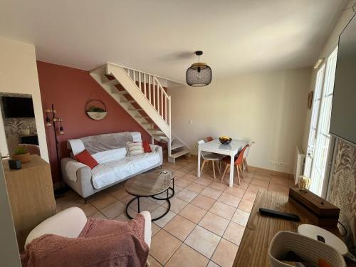 a living room with a staircase and a couch and a table at O'Pale House proche Touquet in Camiers