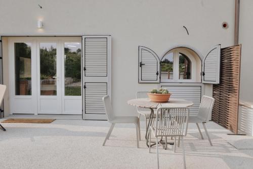 patio con mesa, sillas y puerta en Appartamento VerdeVigna, en Rignano sullʼArno