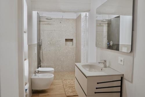 Un baño blanco con lavabo e inodoro. en Appartamento VerdeVigna, en Rignano sullʼArno