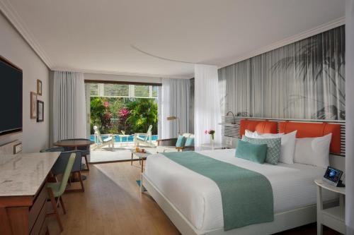 a hotel room with a large bed and a desk at St Martin Beach Resort & Spa in Anse Marcel 