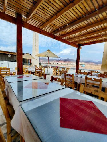 a restaurant with tables and chairs with a view of the beach at Brother Hotel Dahab in Dahab