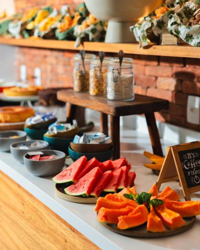a table with plates of fruits and vegetables on it at La Chimère Buzios Essence in Búzios