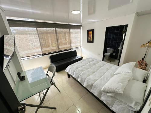 a bedroom with a bed and a couch and a window at Hotel Boutique Kalua in Darién