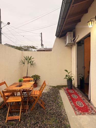 a wooden table and chairs on the side of a house at Suíte Privativa in Florianópolis