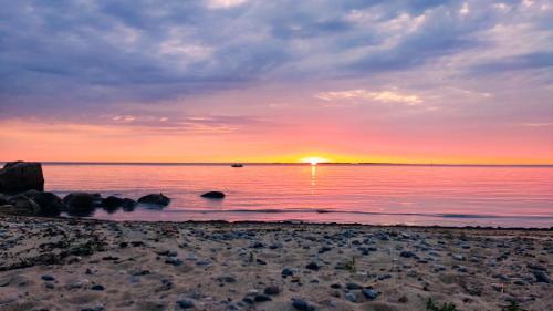 a sunset on the beach with the sun setting at Mereliivatee in Neeme