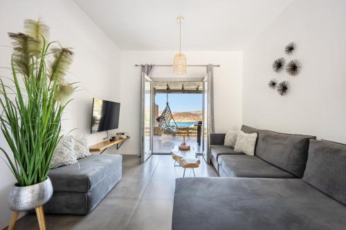 a living room with a couch and a table at Nefeli Residence & Suite Ftelia beach Mykonos in Elia
