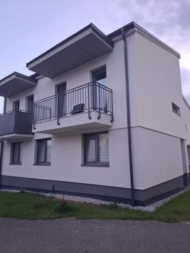 a white apartment building with a balcony at Apartman JAMI in Spišské Podhradie