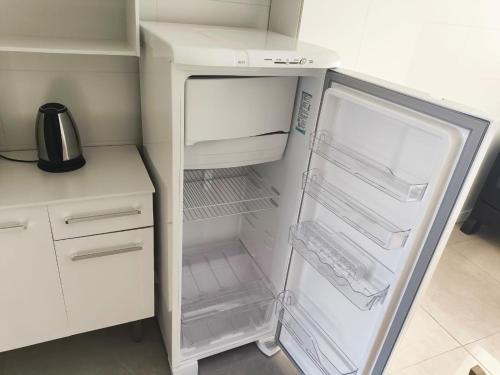 an empty refrigerator with its door open in a kitchen at Lindo apto 3 quartos todo novo in Torres