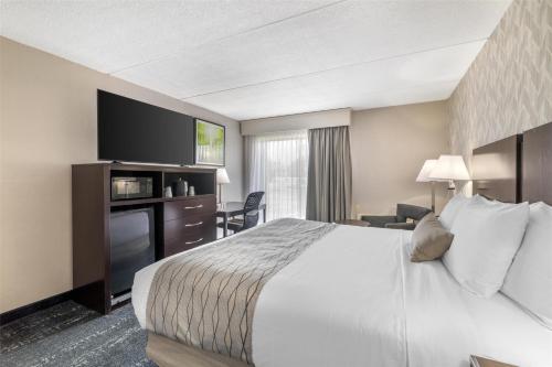 a hotel room with a bed and a television at Best Western Plus Keene Hotel in Keene