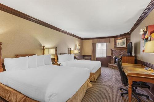 a hotel room with two beds and a desk at Best Western Fireside Inn in Kingston