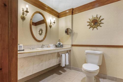 a bathroom with a toilet and a sink and a mirror at Best Western Fireside Inn in Kingston