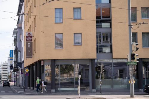 格拉茨Best Western Plus Plaza Hotel Graz的城市街道拐角处的一栋建筑