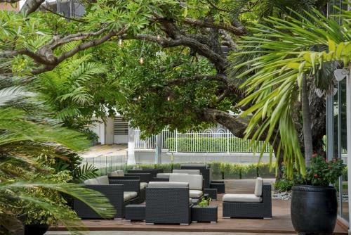 a patio with black and white furniture and trees at NH Collection Royal Smartsuites in Barranquilla