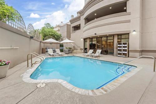 a swimming pool with chairs and a building at Sonesta ES Suites San Antonio Downtown Alamo Plaza - Newly Renovated in San Antonio