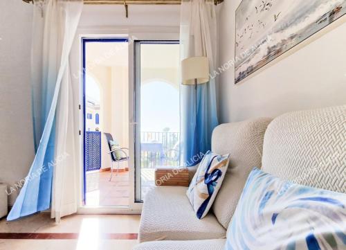 a living room with a couch and a balcony at La Noria de Alicia in San Luis de Sabinillas