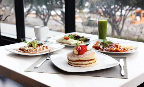 un tavolo con quattro piatti di cibo sopra di Quartz Care Hotel & Spa Tijuana a Tijuana