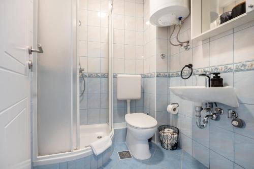 a bathroom with a shower and a toilet and a sink at Apartman Adagio in Neum