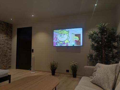 a living room with a flat screen tv on the wall at Apartment in the middle of the city center in a quiet street in Stryn