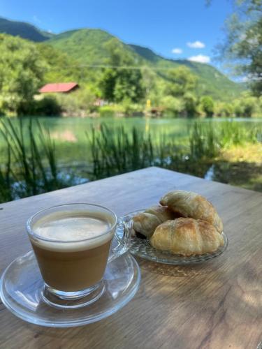 a cup of coffee and two croissants on a table at Vila Jezero-Jajce in Jezero