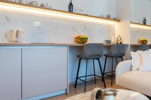 a living room with a counter and two stools at Apartman Adagio in Neum