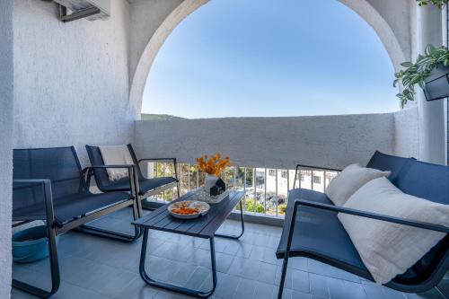 a balcony with chairs and a table and a window at Apartman Adagio in Neum