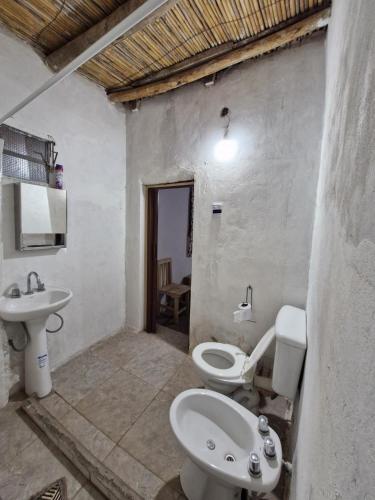 Un baño con un inodoro blanco y un lavabo. en Posada Del Cerro, 