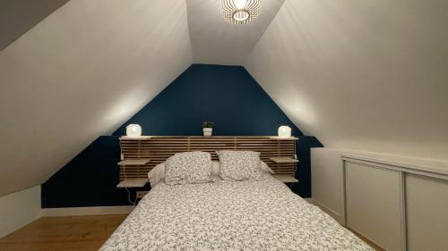 a bedroom with a bed with a blue wall at Maison bretonne - cottage in Lézardrieux