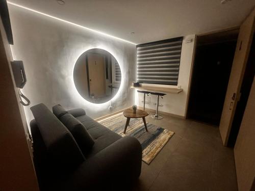 a living room with a couch and a round mirror at Deluxe Armenia Apartment in Armenia