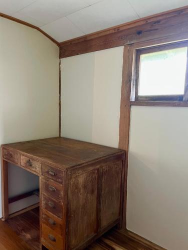 a wooden cabinet in a room with a window at 古民家ステイshinonome inn in Kitsuki