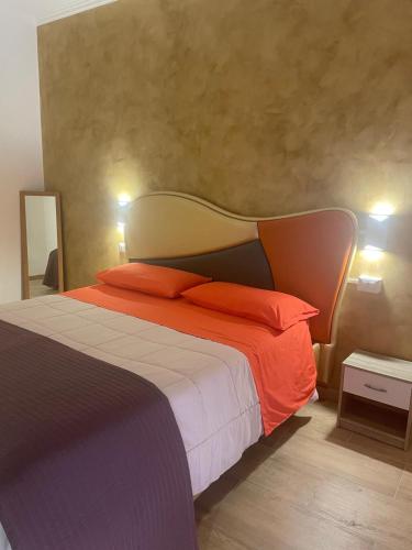 a bedroom with a large bed with orange pillows at B&B Airport 26 in Azzano San Paolo