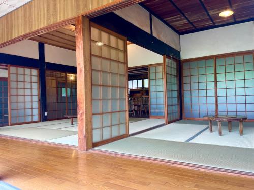 an inside view of a room with white walls and wooden floors at 古民家ステイshinonome inn in Kitsuki