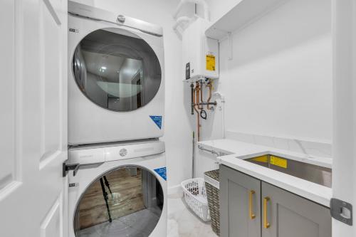 a white laundry room with a washer and dryer at Coco in Farmington Hills
