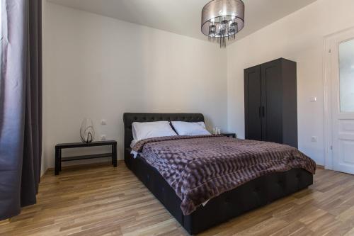 a bedroom with a bed and a black cabinet at Captain Emo City Apartments in Pula